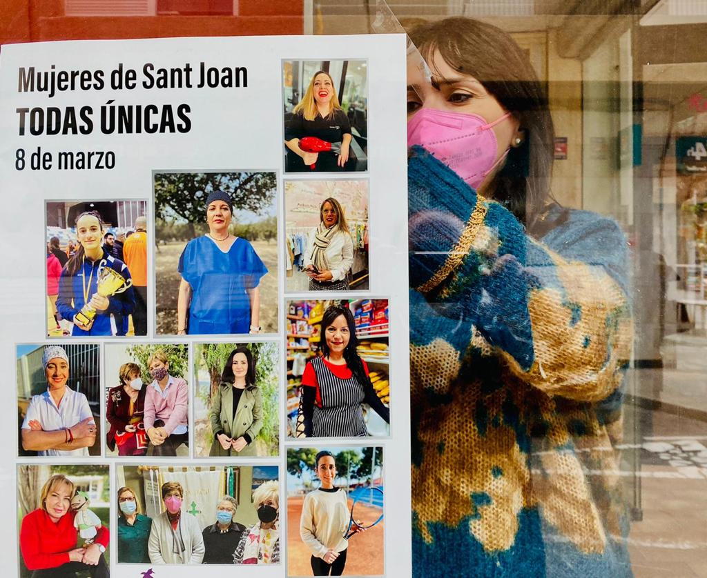 La concejalía de Igualdad, Julia Parra, coloca el cartel del 8M en un escaparate del municipio